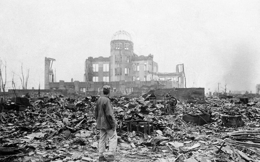 In this Sept. 8, 1945 file photo, an allied correspondent stands in the rubble in front of the shell of a building that once was a exhibition center and government office  in Hiroshima, Japan, a month after the first atomic bomb ever used in warfare was dropped by the U.S. on Aug. 6, 1945.