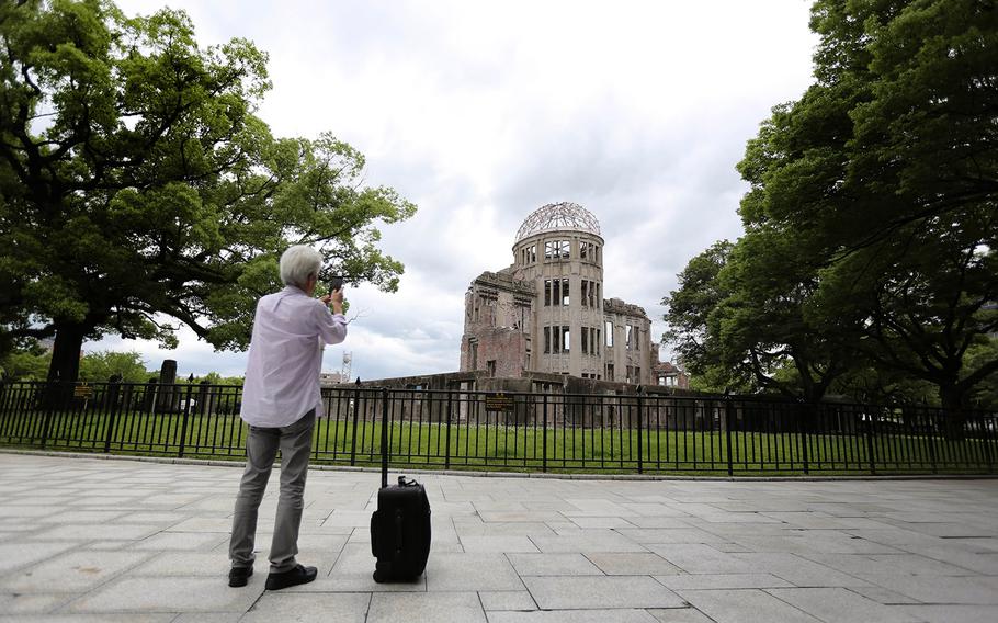 In this July 1, 2015 photo, a visitor photographs now known as Atomic Bomb Dome in Hiroshima, western Japan. On Aug. 6, 1945, a U.S. plane dropped an atomic bomb on Hiroshima, the first nuclear weapon has been used in war. Japan surrendered on Aug. 15, ending World War II.