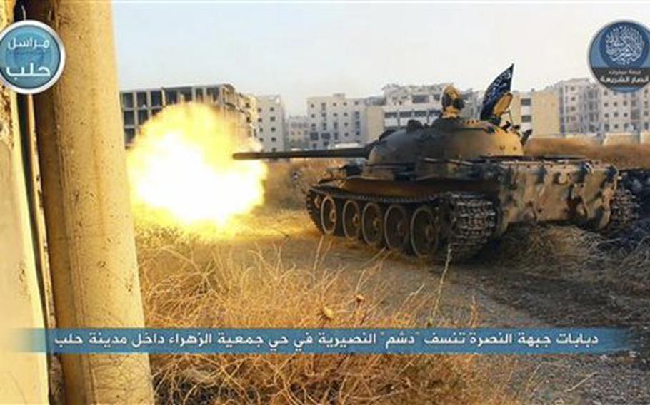 In this file image posted on a Twitter account of Syria's al-Qaida-linked Nusra Front on Tuesday, July 7, 2015, a tank from the Nusra Front fires during their clashes against the Syrian government forces at the western Zahra neighborhood in Aleppo city, Syria. A group of U.S.-trained rebels that recently returned to Syria said Wednesday it has lost contact with one of its officer but is investigating reports that it has defected and handed over his weapons to al-Qaida affiliate in the country. 