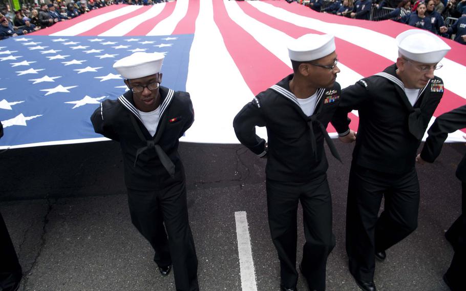 Sailors hold the national ensign as they march during the New York City Veterans Day Parade Nov. 11, 2015. 