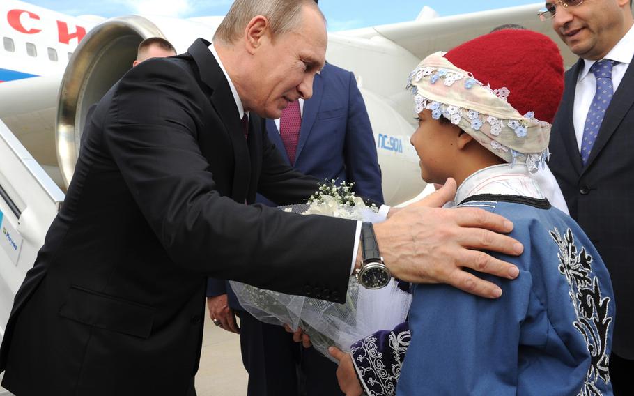 Russian President Vladimir Putin, left, is greeted by children as he arrives at Antalya International Airport in Antalya, Turkey, Sunday, Nov. 15, 2015. 