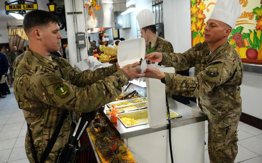 American troops dish out a Thanksgiving Day meal at Bagram Air Field in Afghanistan on Thursday, Nov. 27, 2015. Nearly 10,000 American servicemembers remain in the country.

