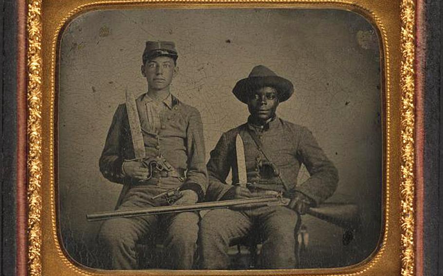 Sgt. A.M. Chandler of the 44th Mississippi Infantry Regiment, Co. F., and Silas Chandler, family slave, with Bowie knives, revolvers, pepper-box, shotgun and canteen.