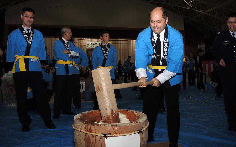 Cmdr. James Schmitt, executive officer of Naval Air Facility Misawa, pounds steamed rice with a traditional wooden mallet during the Japan Self-Defense Force Annual Mochi Pounding Ceremony at Misawa Air Base Dec. 15, 2015. Mochi pounding ceremonies are held to mark many holidays and special occasions in Japan. 