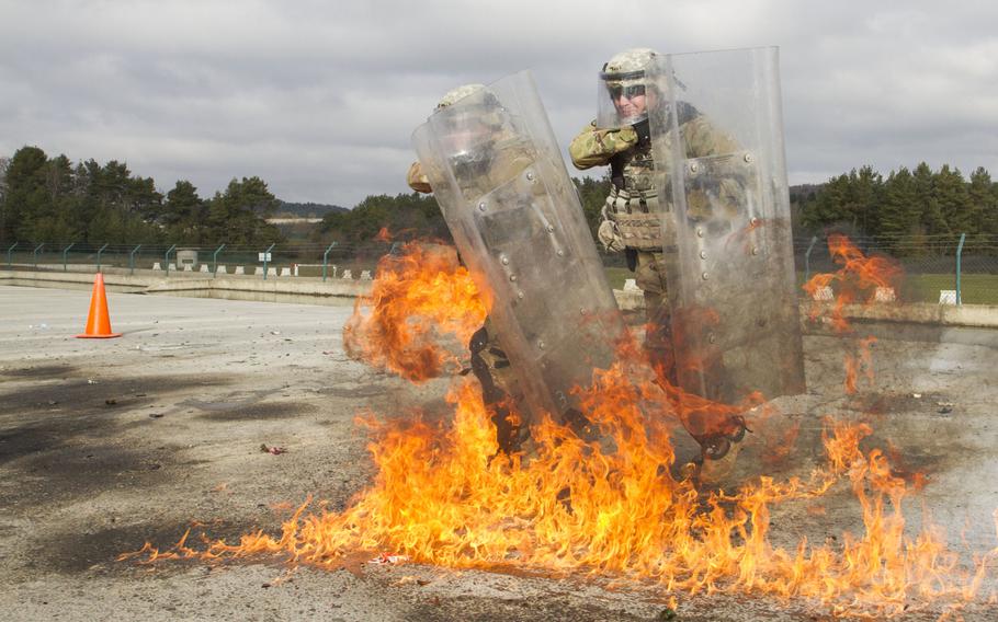 Soldiers from the 1st Battalion, 41st Infantry Regiment, stationed out of Fort Carson, Colo., shield themselves from a Molotov cocktail - a general name used for various bottle-based improvised flammable weapons -- during fire phobia training, Feb. 16, 2016, at the Joint Multinational Readiness Center in Hohenfels, Germany. 