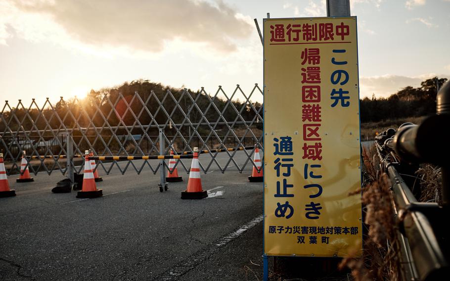 A sign that translates to "Road closed due to 'Difficult to return zone' ahead," sits in front of a barricaded road in the ghost town of Futaba, Japan, less than 10 miles from the severely damaged Fukushima Dai-ichi nuclear power plant Feb. 10, 2016.