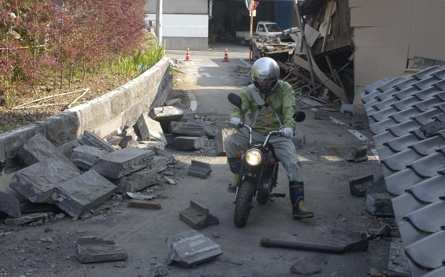 A motorcyclist negotiates earthquake debris in a street near Kumamoto, Japan, on Tuesday, April 19, 2016. More than 40 people have died after two large earthquakes hit the region in 24 hours.


