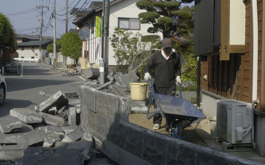 A man clears debris around his earthquake-damaged home near Kumamoto, Japan on Tuesday.  The region was hit by a 6.5 magnitude quake on April 14, then with a 7.3 quake less than 24 hours later. 

