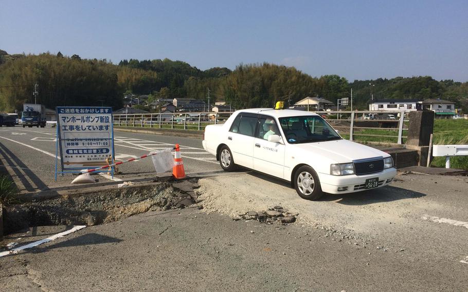 A taxi crosses an earthquake-damaged bridge near Kumamoto, Japan, on Tuesday, April 19, 2016. Two strong earthquakes last week left roads damaged and buildings in ruin.



