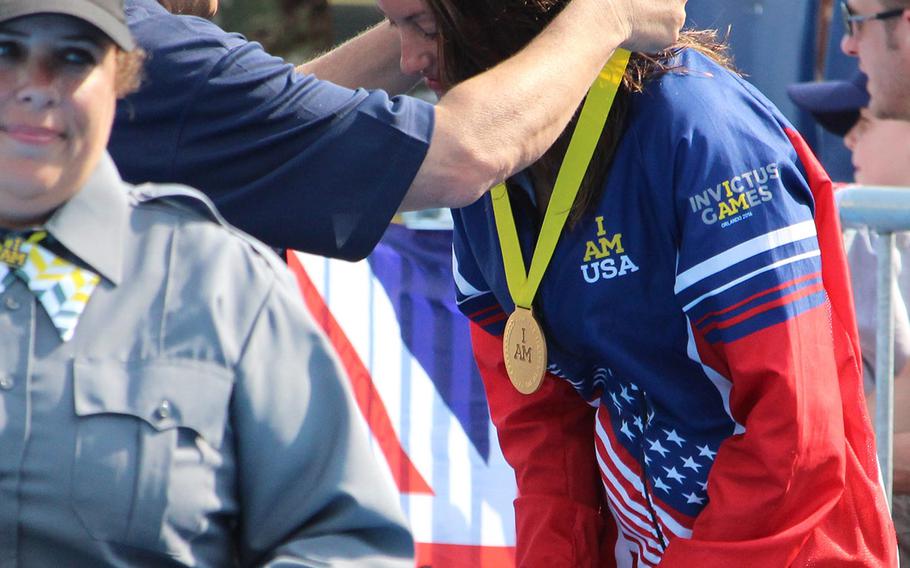 U.S. swimmer Elizabeth Marks accepts the gold medal for the 50-meter backstroke at the 2016 Invictus Games in Orlando, Fla. Marks won four gold medals during the swimming competition.