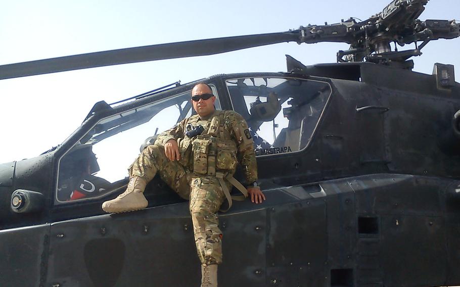 Then  Chief Warrant Officer 3 Miguel Serrano poses with his Apache during one of his deployments to Afghanistan.