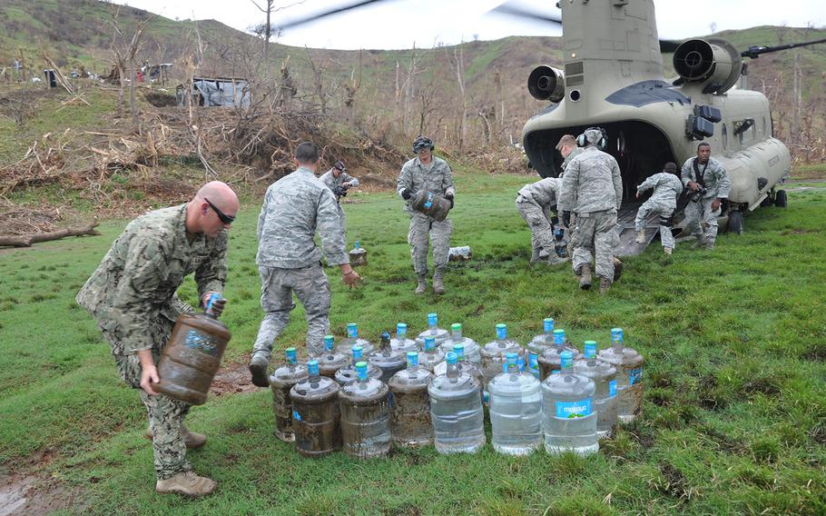 U.S. airmen, sailors and Marines deliver supplies supply onto an Army Chinook helicopter in Port-au-Prince Haiti on Friday Oct. 14, to deliver relief supplies to the southwest village of Anse D’Hainault, which was struck badly by Hurricane Matthew. The supplies included hundreds of pounds of saline for IV treatment of cholera, a growing crisis in the worst hit regions.