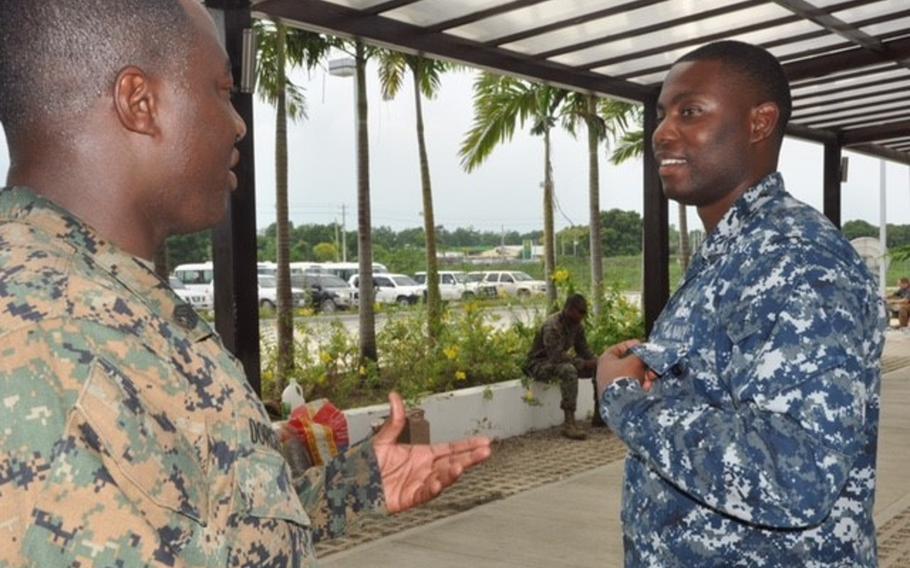 Staff Sgt. Vladimir Dorcelus, left, a cook in the reserve Marine Combat Logistics Battalion 23, jokes around with fellow Haitian, Navy Petty Officer 2nd Class Vladimir Massillon, a database manager based in Jacksonville, Fl. Both men grew up in Haiti and volunteered to assist in the Haiti hurricane relief mission.