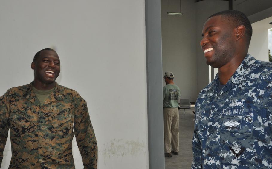 Staff Sgt. Vladimir Dorcelus, left, a cook in the reserve Marine Combat Logistics Battalion 23, talks with fellow Haitian, Navy Petty Officer 2nd Class Vladimir Massillon, a database manager based in Jacksonville, Fl. Both men grew up in Haiti and volunteered to assist in the Haiti hurricane relief mission.