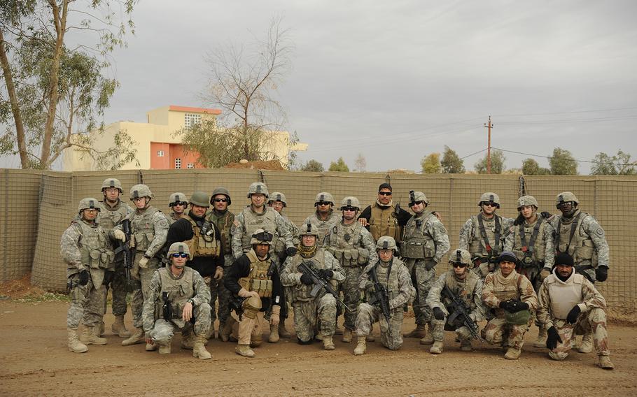 U.S. Army Soldiers of Ironhawk Troop, 3rd Squadron, 3rd Armored Cavalry Regiment from Fort Hood, Texas, and Iraqi soldiers of 3rd Battalion, 3rd Brigade, 1st Iraqi army division pose for a group photo at Baheeza Checkpoint in Mosul, Iraq, Dec. 24, 2008.