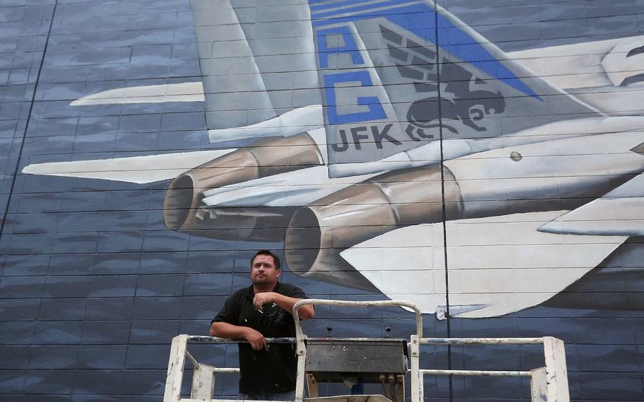 Virginia Beach artist Sam Welty stands in front of a mural he painted in 2013 as a military tribute. The lessee who runs a Howard Johnson in the building sparked controversy when he painted over the mural this week to seal leaks.