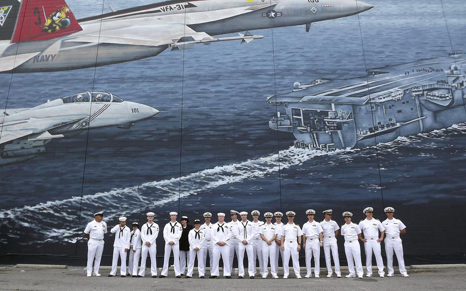 Sailors from Oceana Naval Air Base in Virginia Beach stand in front of a tribute mural at its dedication in 2013. The lessee who runs a Howard Johnson in the building sparked controversy when he painted over the mural this week to seal leaks.