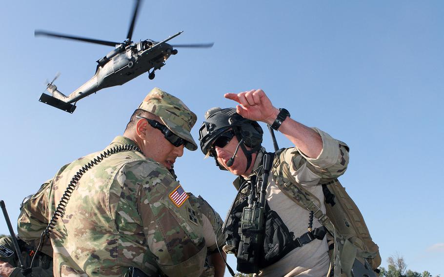 Sgt. Anthony Ayala, left, of the California Army National Guard's 270th Military Police Company, 49th Military Police Brigade, coordinates with an Air Guardsman from the 129th Air Rescue Wing as a UH-60 Black Hawk prepares to land Nov. 17, 2016. 