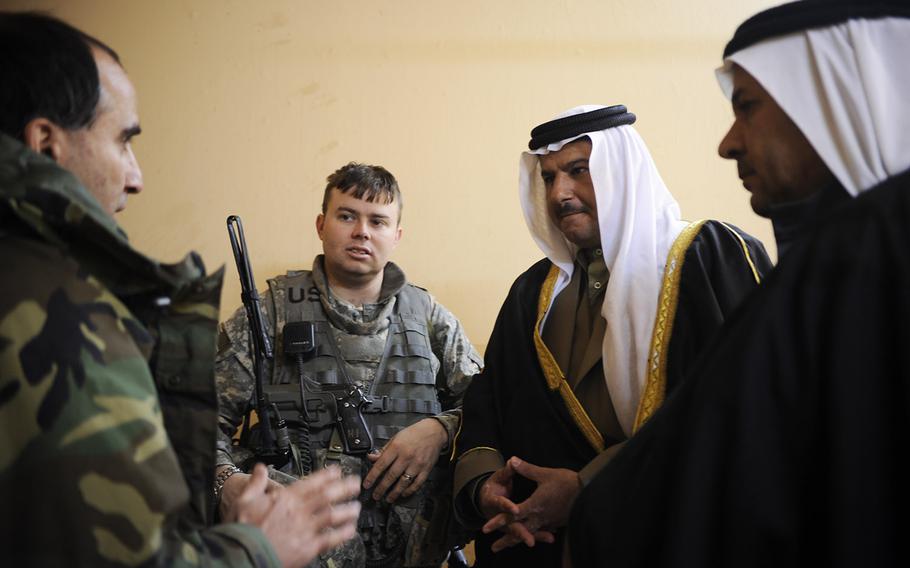 In a 2008 file photo, an interpreter, left, translates for U.S. Army Capt. Matthew Schlosser, 1st Battalion, 8th Infantry Regiment, Fort Carson, Colo., during a meeting with sheiks at an Iraqi police station in Nimrud, Iraq.