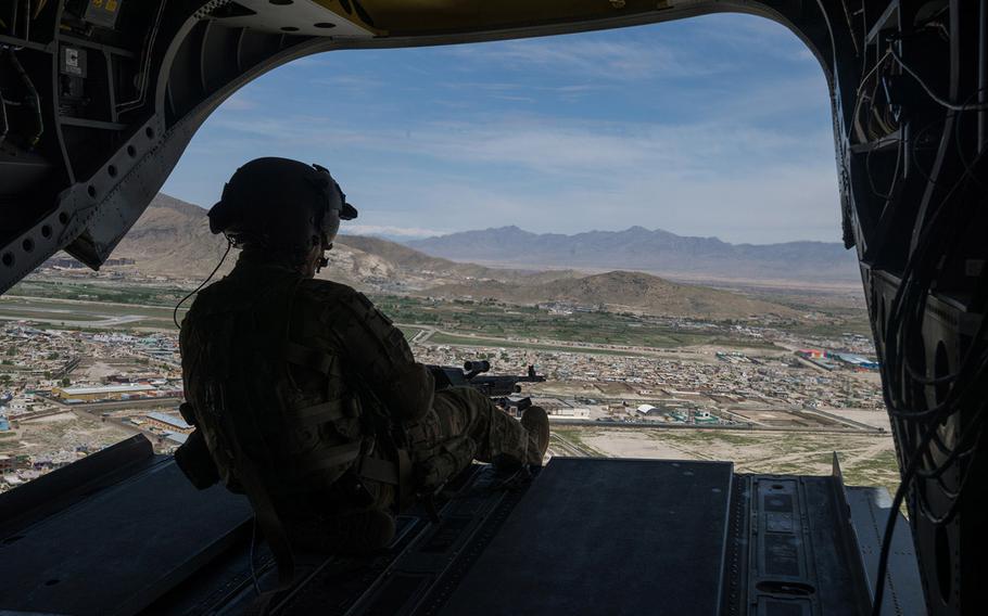 A U.S. soldier looks over Kabul from the back of a CH-47 Chinook Monday, April 24, 2017.