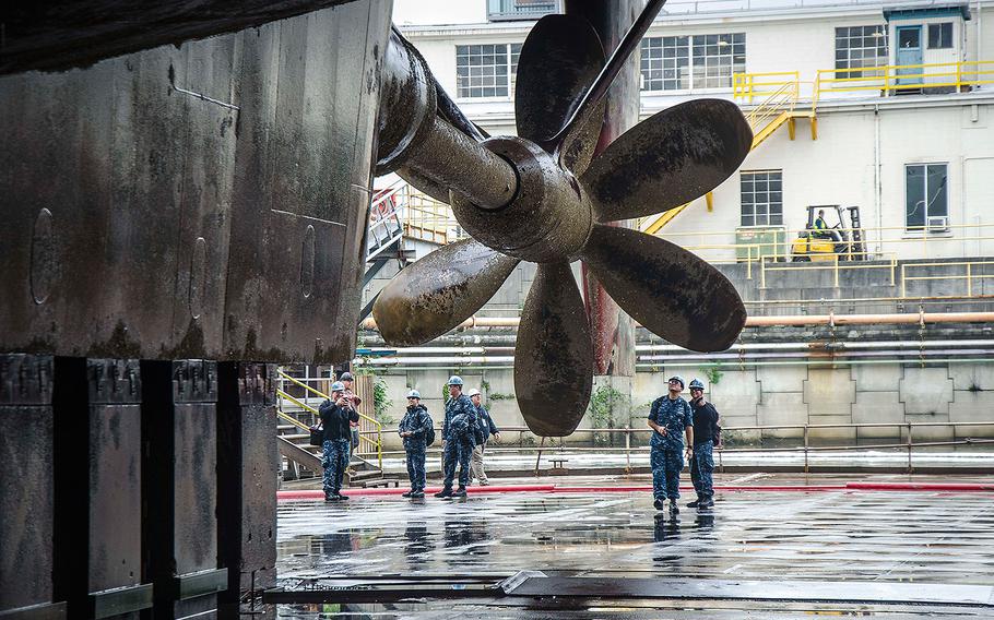 Sailors assigned to the submarine tender USS Frank Cable see their ship's propeller for the first time, as it drains in dry-dock in Portland, Oregon on May 2, 2017. The Frank Cable is in Oregon for scheduled dry-dock phase maintenance.