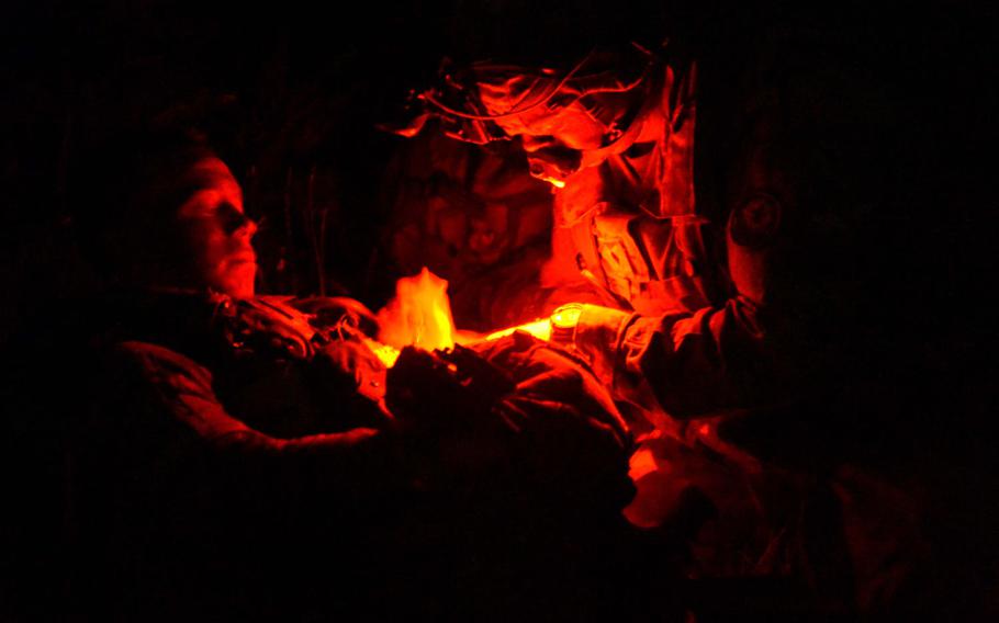A medic checks on a ''wounded'' soldier during a night river crossing operation of the Olt River near Ramnicu Valcea, Romania, late Sunday, July 16, 2017. Soldiers of the 2nd Cavalry Regiment with their Strikers and support vehicles crossed the Olt on two bridges set up by Romanian and German troops.