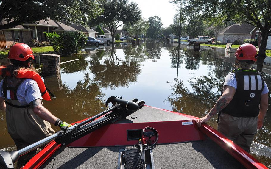 Megan McKee, left, of Fort Worth, Texas, and Anthony DiToma, of Dallas, pull a boat up a flooded street in a Beaumont, Texas neighborhood on Sept. 2. McKee, a Navy veteran and DiToma, son of an Army vet, were participating in search and rescue with the veterans disaster relief non profit Team Rubicon.