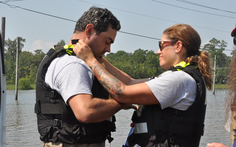 Navy veteran Megan McKee, right, helps Team Rubicon teammate Anthony DiToma of Dallas fit his floatation vest before they enter the flooded areas of Beaumont, Texas on Sept. 2 on their boat to search for people who might be trapped in their homes. The volunteer organization utilizes veterans skills to assist in disaster zones.