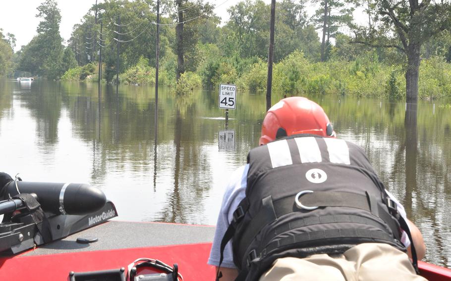 Team Rubicon volunteer Anthony DiToma of Dallas keeps an eye out for debris in the floodwaters in Beaumont, Texas on Sept. 2, 2017. The 45 mile per hour sign is one of few indications that the waterway is normally a busy roadway.