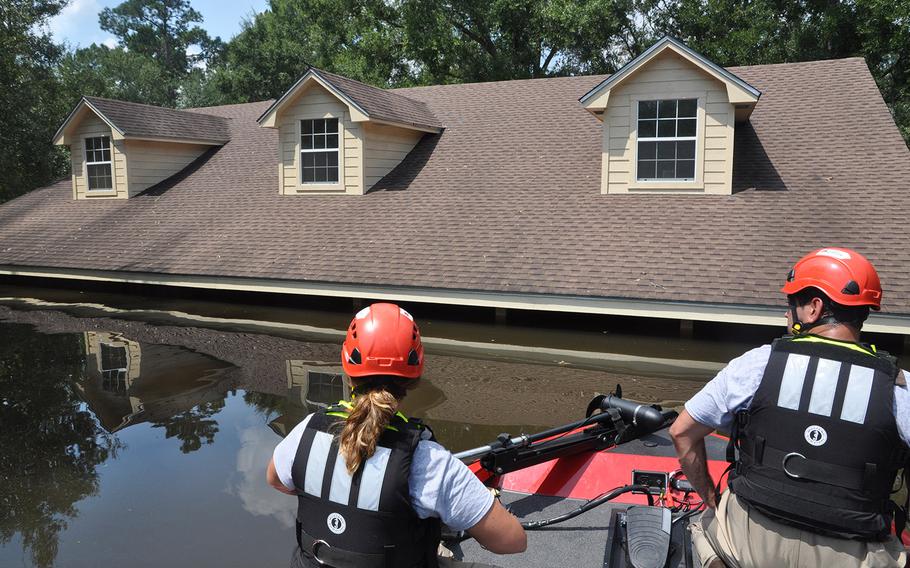 Navy veteran Megan McKee, left, and Team Rubicon teammate Anthony DiToma of Dallas sit at the front of their Team Rubicon search and rescue boat as they make their way from house to house in a flooded neighborhood of Beaumont, Texas on Sept. 2. The volunteer veterans organization has been helping search for people who might be trapped in their homes. 