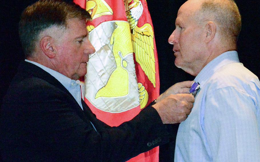 Retired Lt. Gen. Terry Robling pins the Purple Heart medal on Vietnam veteran Mike Sanzaro in a ceremony in San Diego on Sept. 23, 2017.