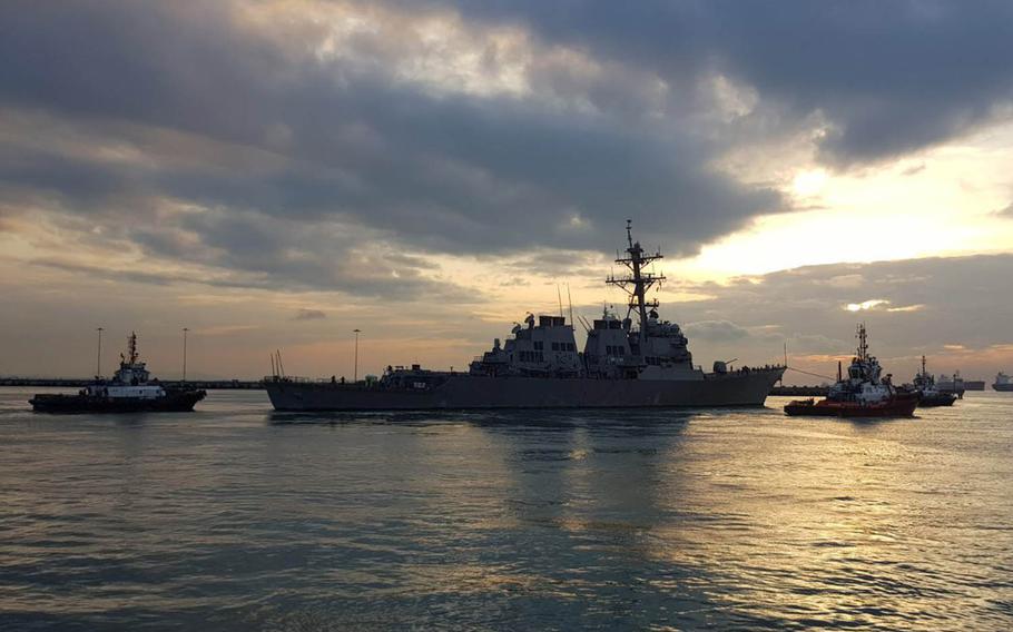 The USS John S. McCain is towed away from the pier at Changi Naval Base, Singapore, to meet the heavy-lift transport vessel MV Treasure, Thursday, Oct. 5, 2017.
