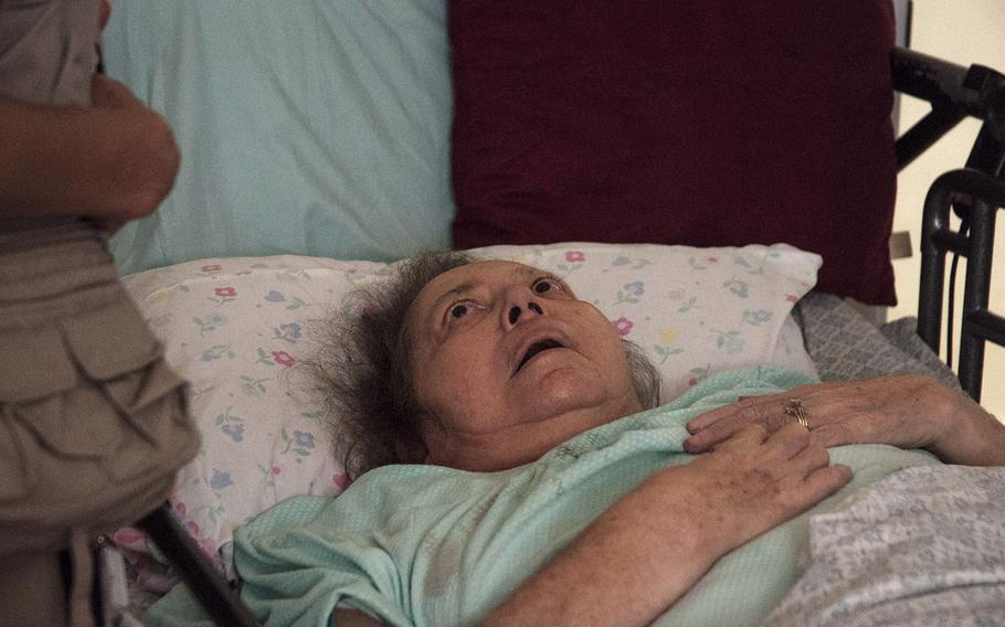 Luz Morales looks up from her bed as a Red Cross worker prepares to give a medical examination while visiting elderly residents in the Ciales region of Puerto Rico, on Nov. 12, 2017.