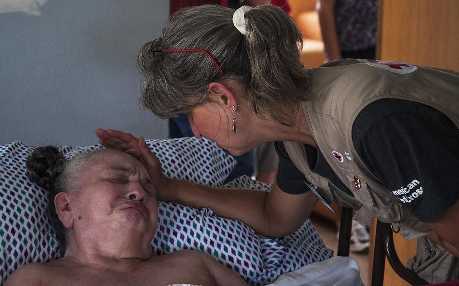 Red Cross disaster relief worker Winnie Romeril offers comfort after being invited to a home where an elderly resident was bed ridden in the Ciales region of Puerto Rico, on Nov. 12, 2017.