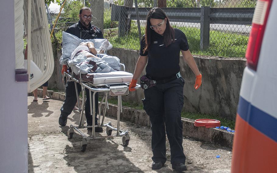 An ambulance crew hauls away Korean War veteran Agostin Figueroa from his sister's home in the Ciales region of Puerto Rico, on Nov. 12, 2017, after a Red Cross team visited and determined that immediate medical care was needed to treat a painful infection that had spread from the feet throughout the body.