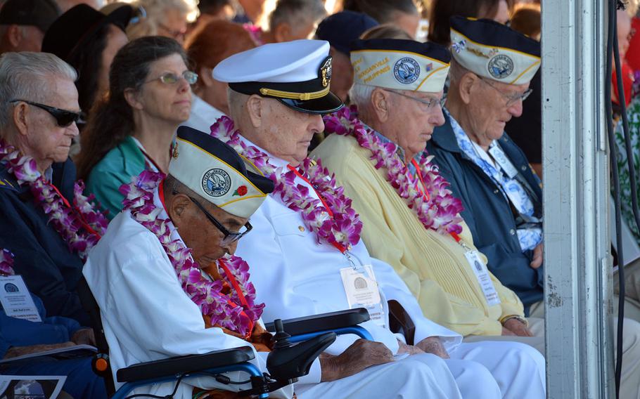 Survivors of the Dec. 7, 1941, surprise attack on Pearl Harbor bow their heads during a prayer at the Pearl Harbor Visitor's Center at the 76th anniversary ceremony, Thursday, Dec. 7, 2017.