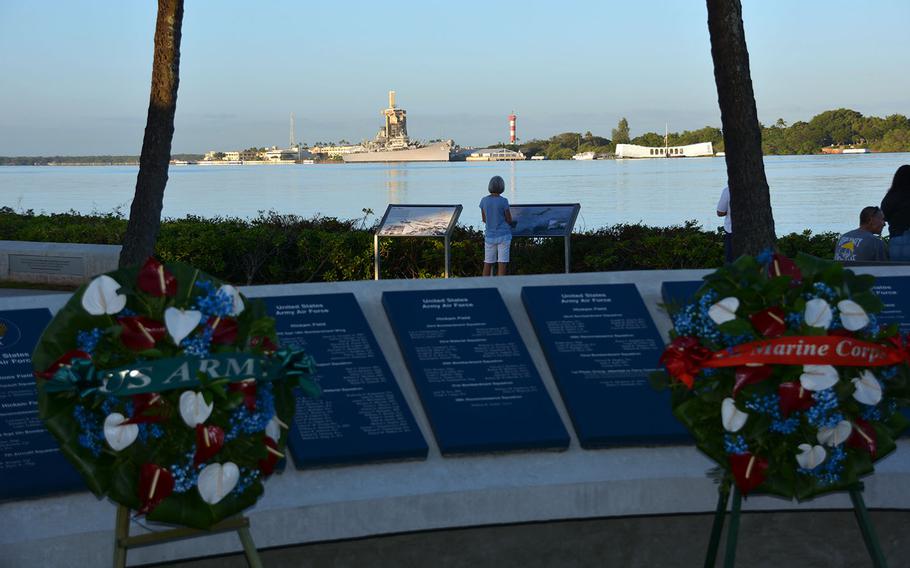 Service wreaths presented Thursday, Dec. 7, 2017, as part of the ceremony for the 76th anniversary of the Pearl Harbor attack stand at the Pearl Harbor Visitor's Center, with the USS Arizona and USS Battleship Missouri memorials in the background.