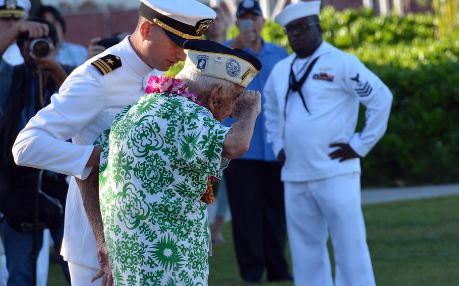 Lt. Cmdr. Michael Genta steadies Al Rodrigues as he leads a ceremony rendering honors to the USS Arizona crew entombed in the ship that lies on the bottom of Pearl Harbor, Thursday, Dec. 7, 2017. 