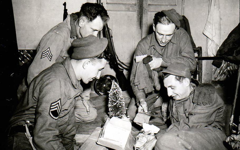 Sitting around a miniature Christmas tree and opening a Christmas package are (front row, left to right) S/Sgt. John F. Suchanek; and Pfc. Joseph G. Pierro; and (back row) Sgt. Charles M. Myrich; and Sgt. Leon L. Oben. All are members of F. A. Bn., 3rd Div. Pietramelara, Italy. December 16, 1943. 
