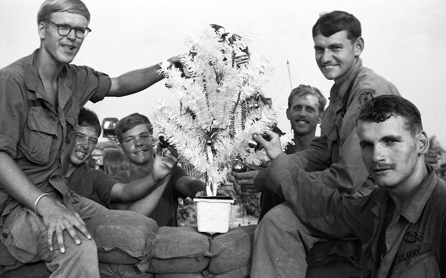 South Vietnam, December, 1969: Soldiers from 2nd Battalion, 27th Infantry gather around their Christmas tree at Patrol Base Kotrc, near the Cambodian border. The tree was a gift from a women's organization in Seattle.