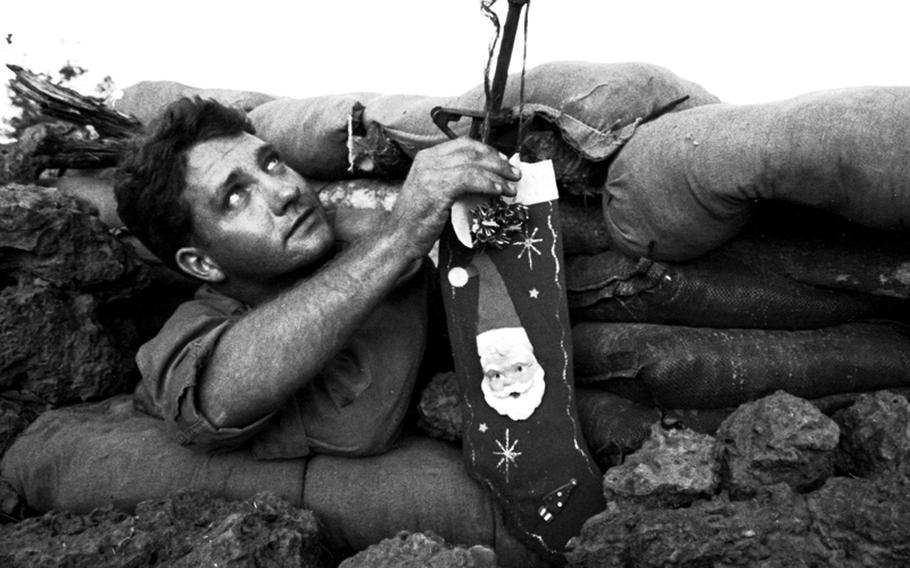 South Vietnam, December, 1967: Pfc. Orville Painter, 22, of Modesto, Calif., leans out of his bunker at Ka Tum, 50 miles northwest of Saigon, to hang his Christmas stocking. He jokingly pointed to the sky and said, "Santa Claus will assault from there." Painter is with C Company, 2nd Battalion, 14th Infantry, 25th Infantry Division.