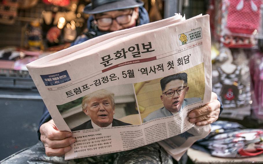 A man reads a copy of the Munhwa Ilbo newspaper featuring President Trump and North Korean leader Kim Jong Un on the front page in Seoul on March 9, 2018. 