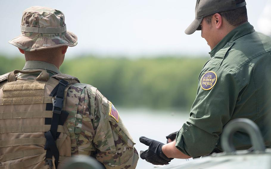 A Texas Guardsmen and a U.S. Border Patrol agent talk on April 10, 2018 at the shore of the Rio Grande River in Starr County, Texas.