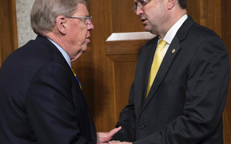 Secretary of Veterans Affairs nominee Robert Wilkie, right, shakes hands with Senate Veterans' Affairs Committee Chairman Johnny Isakson, R-Ga., before a hearing on Capitol Hill, June 27, 2018.
