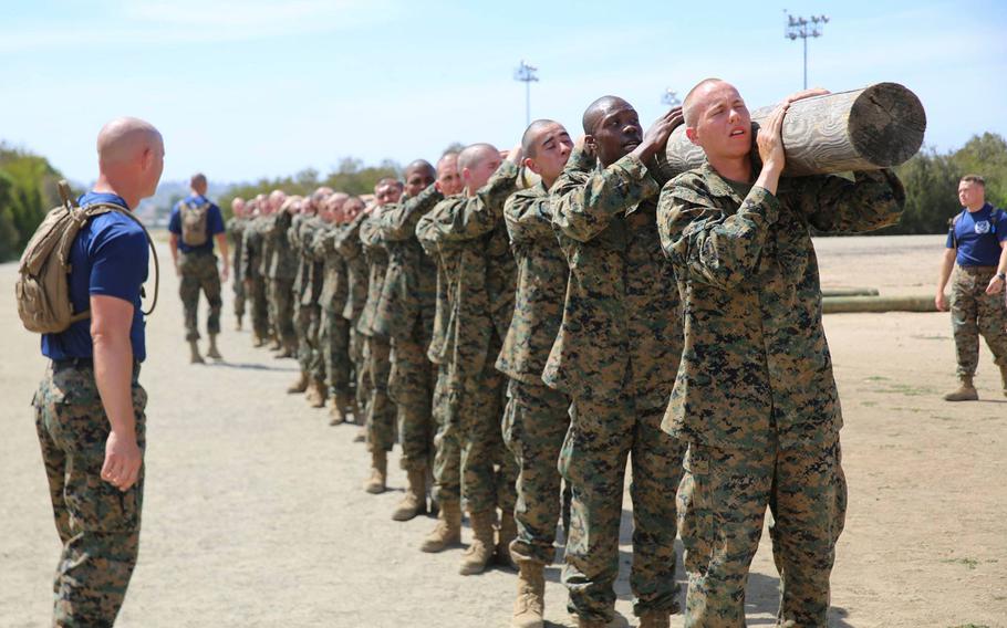 Recruits at Marine Corps Recruit Depot San Diego carry a log during a log drill exercise at Marine Corps Recruit Depot San Diego, April 23, 2018. A former Marine recruit discharged last year after contracting the bacteria E. coli during the final phases of training at the Marine Corps Recruit Depot San Diego filed a lawsuit blaming the company that supplies food to the military base for his illness.