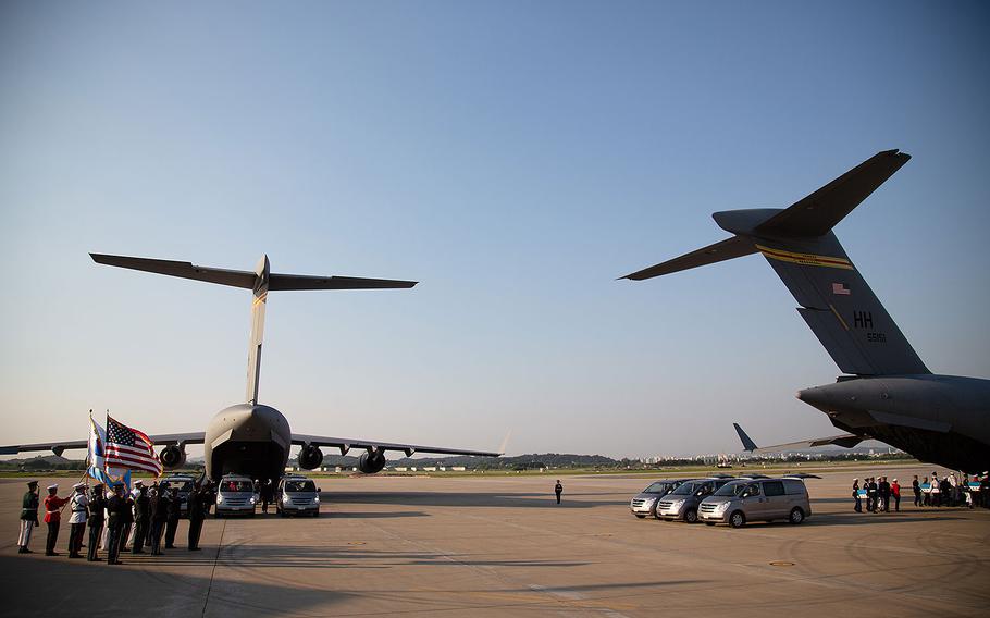 Six caskets are loaded onto two Air Force transport planes at Osan Air Base, South Korea, for their trip to Hawaii, Wednesday, Aug. 1, 2018.