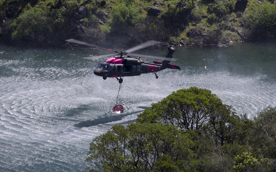 An Army National Guard UH-60 Black Hawk helicopter picks up water from Pardee Reservoir, in Ione, California, Saturday, April 14, 2018, during interagency aircrew training with CAL FIRE.
