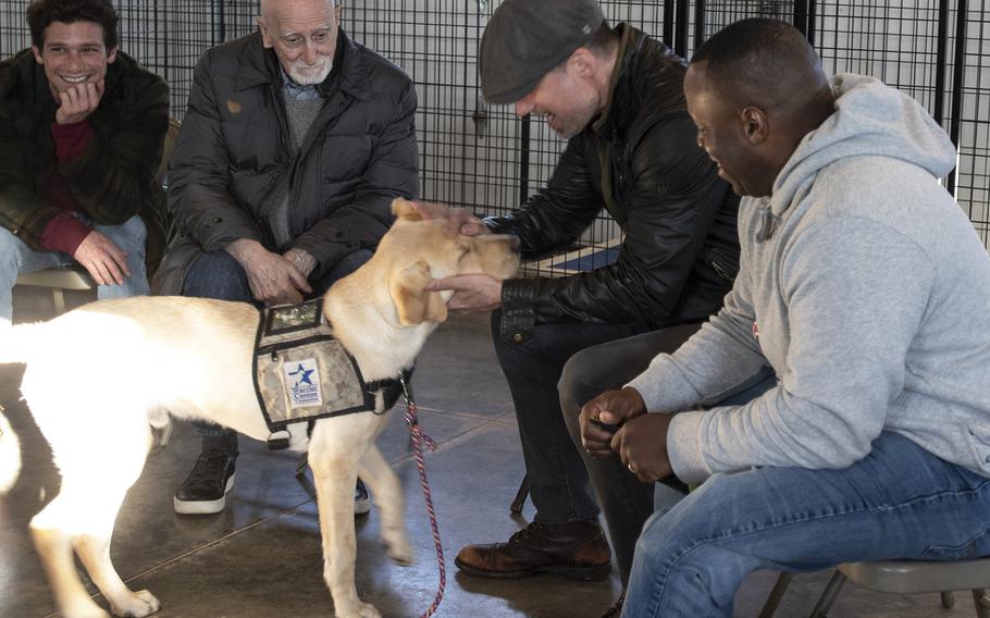 Cast of the new TV show "The Village" visit Warrior Canine Connection in Boyds, Maryland, on November 10, 2018, to learn about service dogs and their role helping veterans. The show will air in 2019. From left to right: actors Daren Kagasoff, Dominic Chianese and Warren Christie and military consultant Jamel Daniels. 