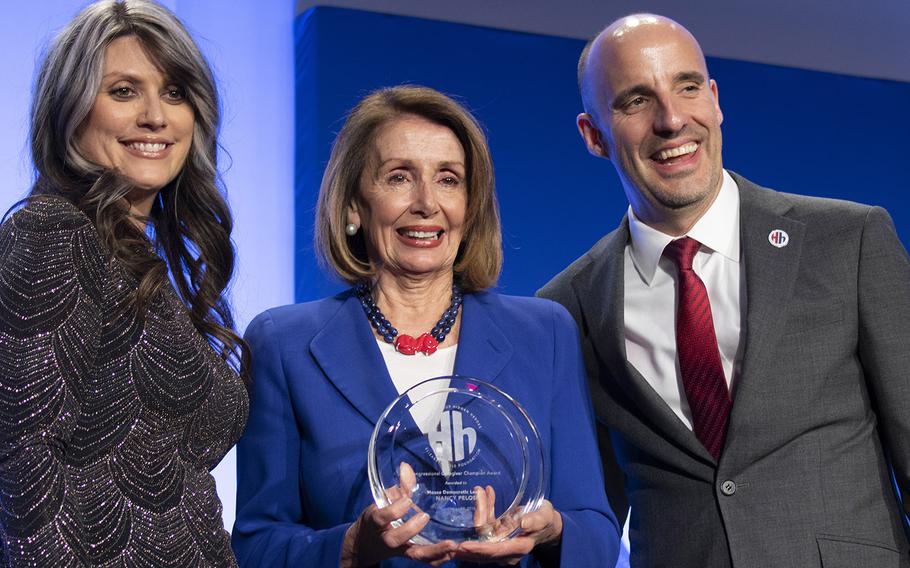 House Minority Leader Nancy Pelosi, D-Calif., center, is presented with the Congressional Caregiver Champion Award by military caregiver Nikki Stephens and Steve Schwab, executive director of the Elizabeth Dole Foundation, during the foundation's Heroes and History Makers event in Washington, D.C., Nov. 29, 2018.