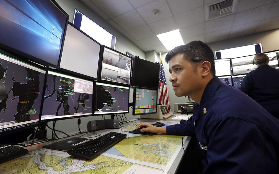 In a Wednesday, Jan. 16, 2019 file photo, U.S. Coast Guardsmen Gustavo Rosas, who missed his first paycheck a day earlier during the partial government shutdown, monitors marine vessel traffic at Sector Puget Sound base in Seattle.